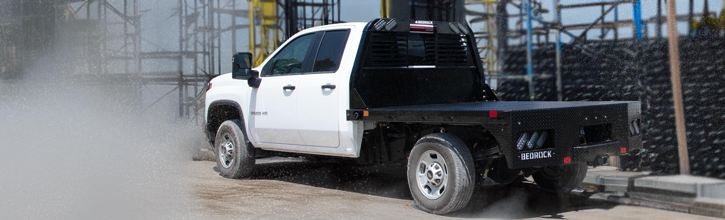 Bedrock Diamond Series flatbed on a white Chevy 2500HD at a construction site