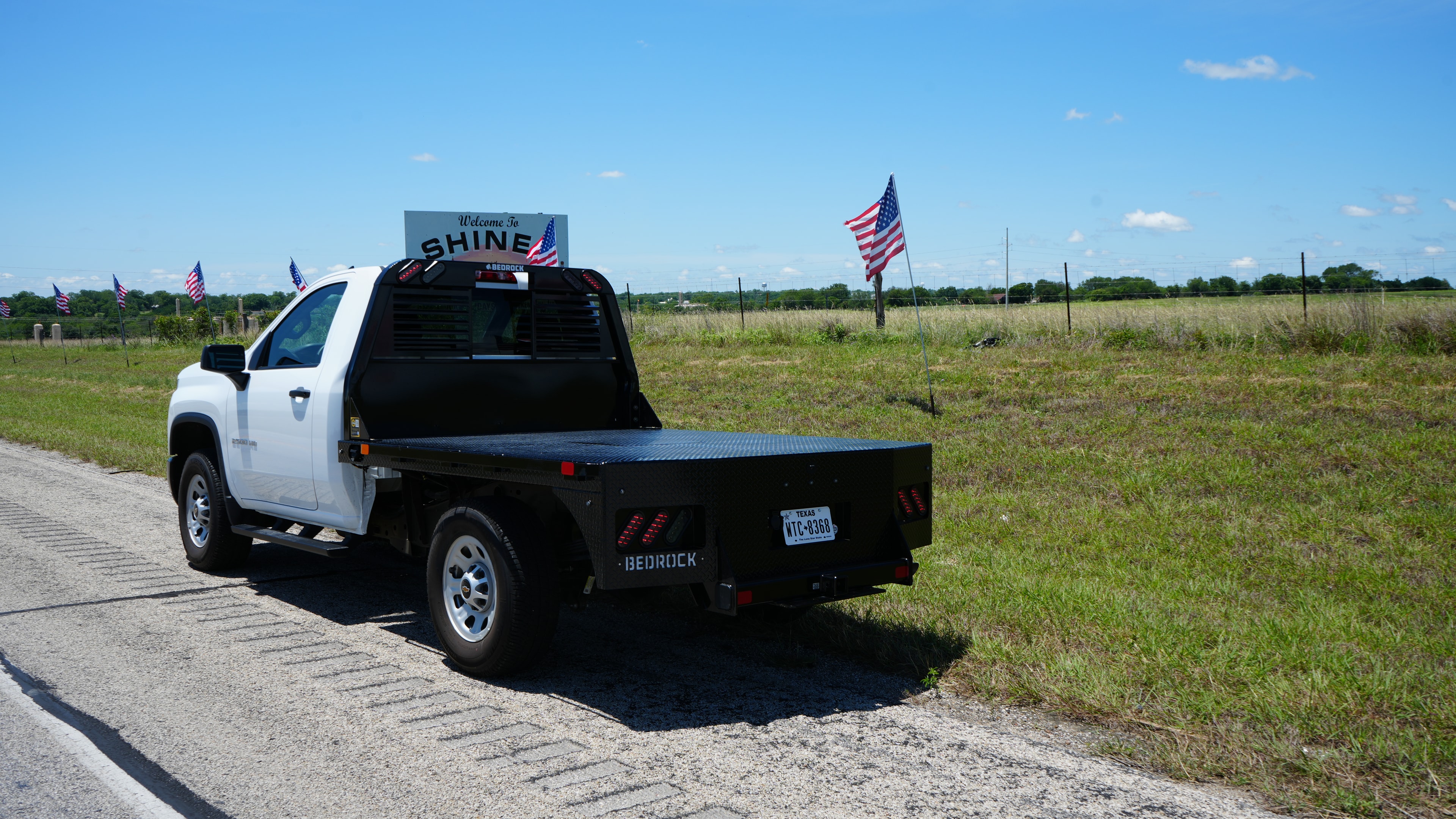 Bedrock Diamond Series flatbed on a white pickup truck at a rural roadside